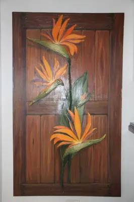 a painting of two flowers on a wooden wall at Strelitzia, spacious with a stunning view in Cape Town