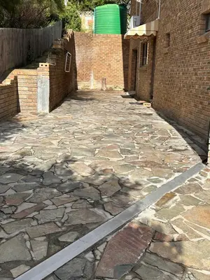 a stone walkway next to a brick building at Strelitzia, spacious with a stunning view in Cape Town