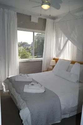 a bedroom with a large white bed with towels on it at Valentines Hermanus in Hermanus