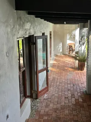 an open door of a building with a brick patio at Hidden Gem on Onrus River in Hermanus
