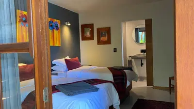 a bedroom with two beds and a mirror at Hidden Gem on Onrus River in Hermanus