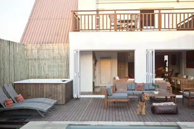 a dog standing on a deck with a patio at Villa Del Mar in Clareport
