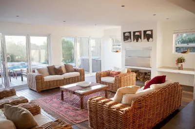 a living room with wicker furniture and a fireplace at Villa Del Mar in Clareport