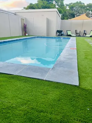 a swimming pool in a yard with grass at Sixth Avenue Residence Halaal Accommodation Cape Town in Cape Town