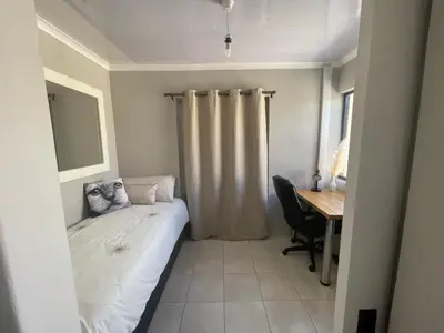 a small bedroom with a bed and a desk at Sixth Avenue Residence Halaal Accommodation Cape Town in Cape Town