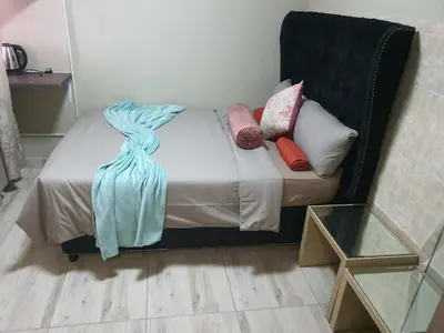 a small bed with pillows on it in a room at Mabel Guesthouse in Cape Town