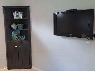 a black book shelf with a flat screen tv at Oak Village in Stellenbosch