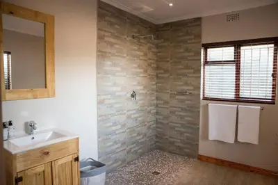 a bathroom with a sink and a mirror at Sol Montis Guest Cottage in Paarl