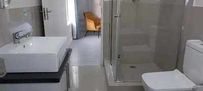 a bathroom with a sink and a shower and a toilet at LND GUEST HOUSE in Bloubergstrand