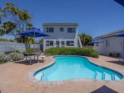 a swimming pool in front of a house at Southeaster in Bloubergstrand