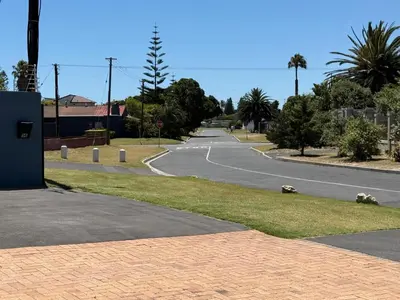 an empty street with a road in the middle at Southeaster in Bloubergstrand
