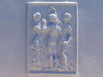 a statue of three people on a wall at Southeaster in Bloubergstrand