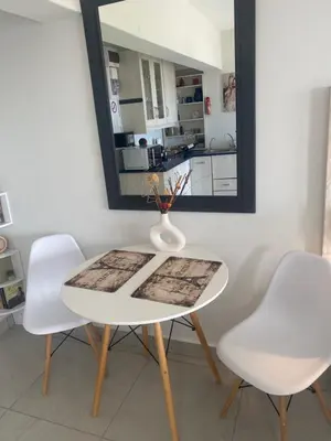 a white table with two white chairs and a mirror at Seaview Sunset Boutique Apartments Gordonsbay Solar powered in Cape Town