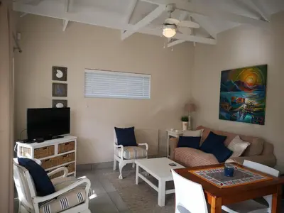 a living room with a couch and a table at Seashell Cottage in Hermanus