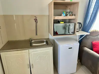 a small kitchen with a sink and a microwave at Mowetu Guest House in Cape Town