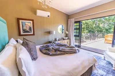a bedroom with a bed and a large window at Val de Vine in Stellenbosch
