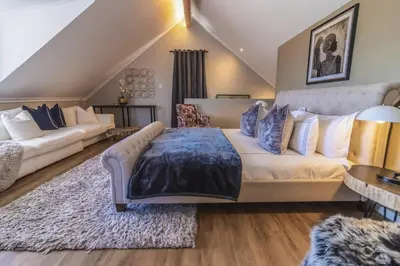 a living room with a large bed and a couch at Val de Vine in Stellenbosch
