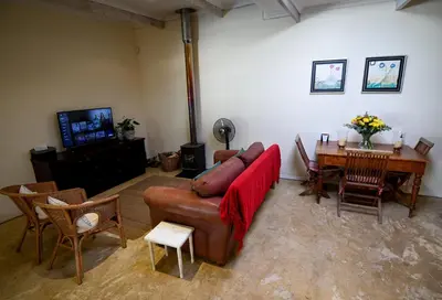a living room with a couch and a table at Cabriere Cottage in Franschhoek