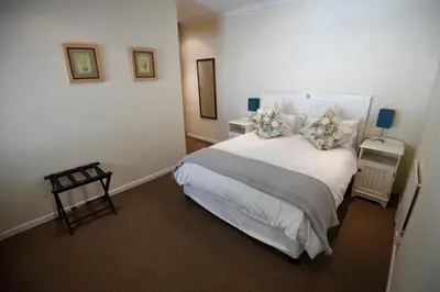 a bedroom with a large white bed with pillows at Cabriere Cottage in Franschhoek