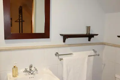a bathroom with a sink and a mirror and towels at 3 on Roux in Franschhoek