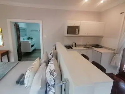 a white kitchen with a bed in a room at Beulah Lodge in Cape Town