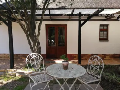 a table and two chairs in front of a house at Beulah Lodge in Cape Town