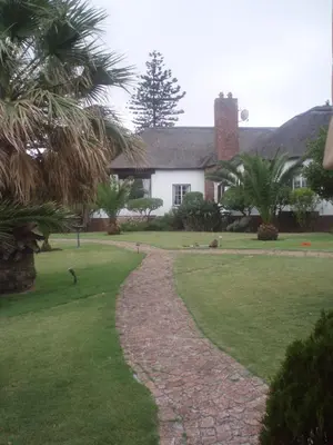 a house with a stone path in front of a yard at The Sanctuary Guest House Estate in Cape Town