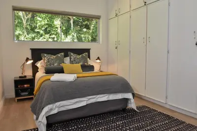 a bedroom with a large bed and a window at Fernkloof Cottage in Hermanus