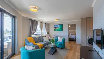 a living room with a couch and a tv at Shore2Please in Cape Town