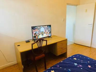 a desk with a computer on top of it in a bedroom at Peaceful getaway in Cape Town