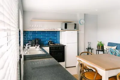 a small kitchen with a sink and a table at The Salene Hotel & Apartments in Stellenbosch