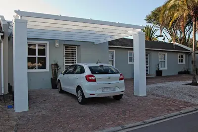 a white car parked in front of a house at Aloe Aloe Cottage in Cape Town