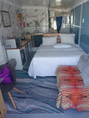 a bedroom with a large bed and a desk at Cozy Private En Suite Studio in Cape Town