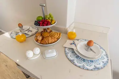 a table with a breakfast of eggs and fruit at C'estÇa Cottage Modern Luxurious Sounds of the Sea in Hermanus