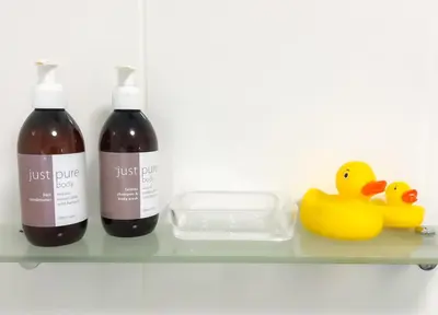 two bottles of wine and two rubber ducks on a shelf at C'estÇa Cottage Modern Luxurious Sounds of the Sea in Hermanus