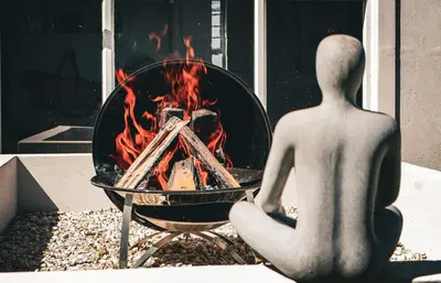 a mannequin sitting in front of a fire pit at C'estÇa Cottage Modern Luxurious Sounds of the Sea in Hermanus