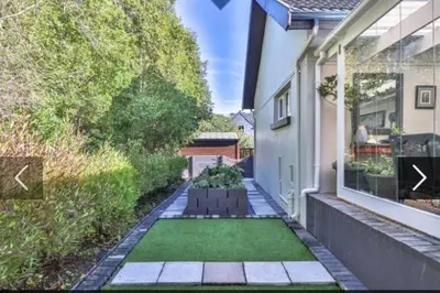 a garden with a lawn in front of a house at In die Hoekie in Hermanus