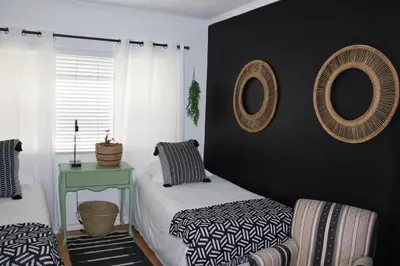 a bedroom with two beds and two mirrors on the wall at sonsandsee in Hermanus