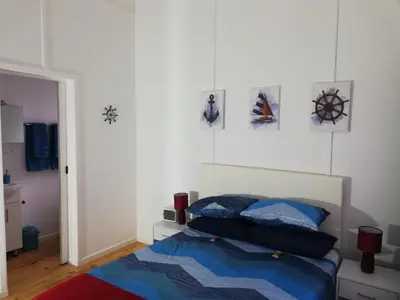 a bedroom with a bed and some pictures on the wall at Glenley place in Hermanus