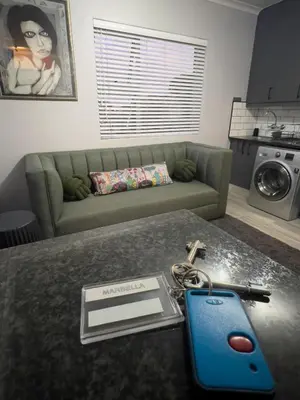 a living room with a couch and a table with a key at Marbella - Cozy studio in Heart of Table View in Cape Town