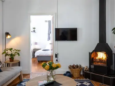 a living room with a fireplace and a couch at Jonkershoek Valley Cottage in Stellenbosch