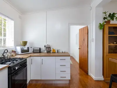 a kitchen with white cabinets and a stove at Jonkershoek Valley Cottage in Stellenbosch