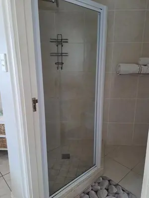 a shower with a glass door in a bathroom at Palmsbeach 3 in Strand