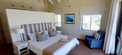 a bedroom with a large white bed and a window at Knight's House in Hermanus