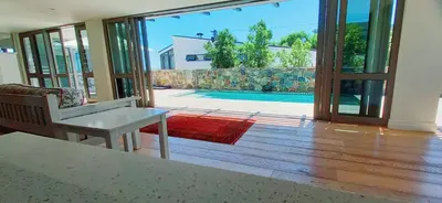 a living room with a sliding glass door with a view of a pool at Knight's House in Hermanus