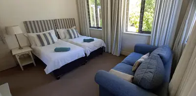 a bedroom with a bed and a blue couch at Knight's House in Hermanus