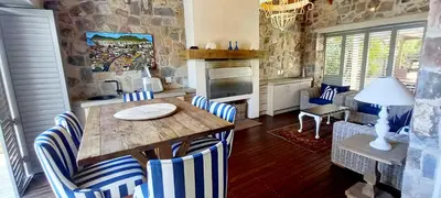 a kitchen with a wooden table and blue and white chairs at Knight's House in Hermanus