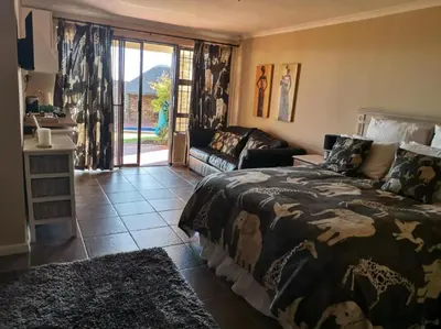 a bedroom with a bed and a couch at Plattekloof Treasures in Cape Town