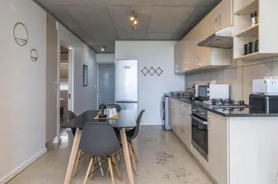 a kitchen with a table and some chairs in it at Sea and Sun-Table Mountain views Wifi Parking! in Cape Town
