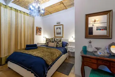 a bedroom with a bed and a vanity and a mirror at Art Box in Greyton